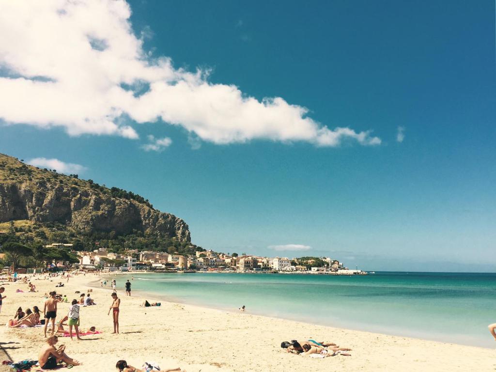 a group of people on a beach near the water at Beach House Mondello in Mondello