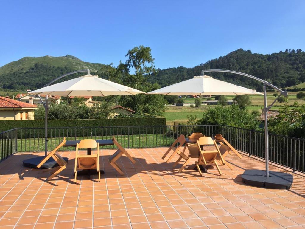 a group of chairs and umbrellas on a patio at La Posada de Granda in Cuenco