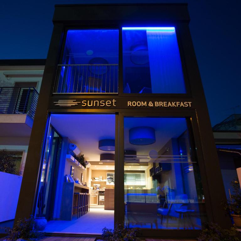 a building with a sign that reads sunset room and breakfast at Sunset Room&Breakfast in Grado