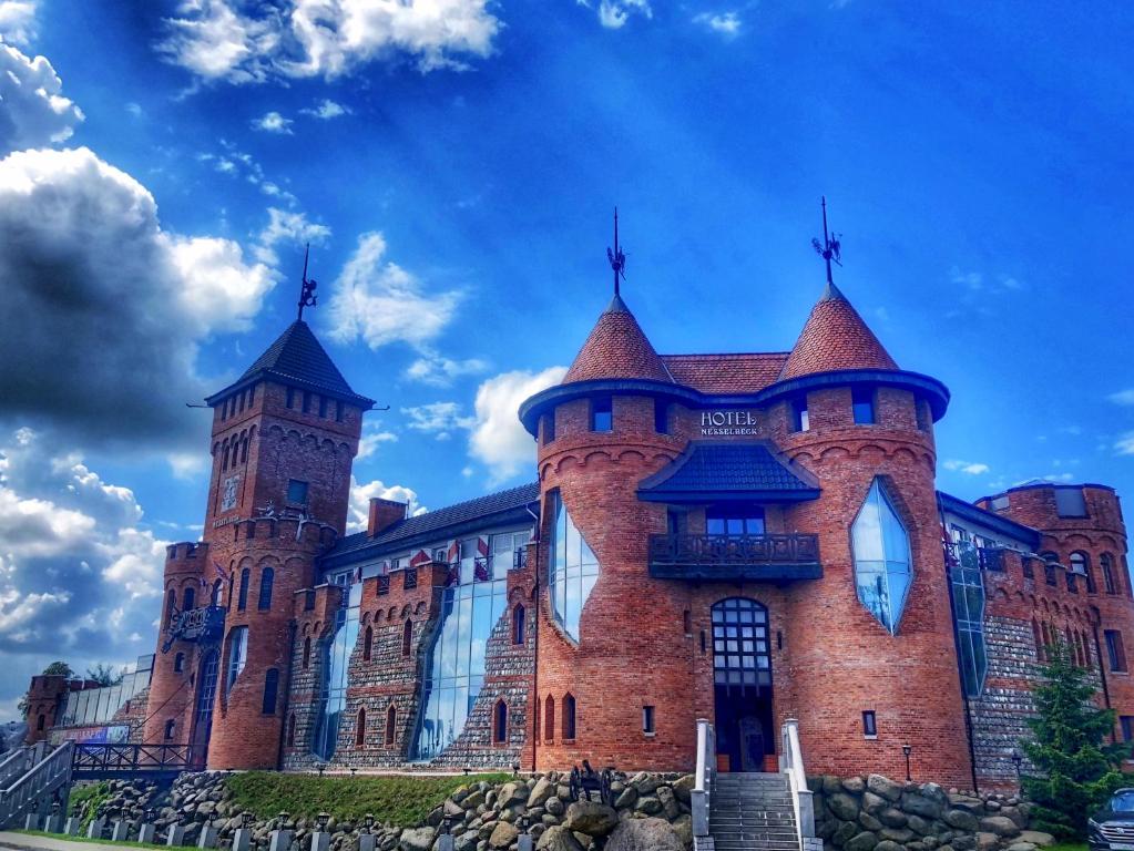 a large red brick building with a tower at Nesselbeck in Orlovka