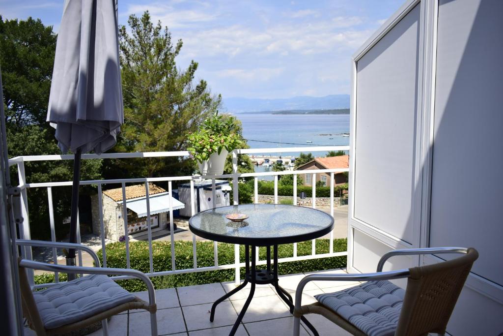einen Balkon mit einem Tisch und Stühlen sowie Meerblick in der Unterkunft Apartment Rina in Vantačići