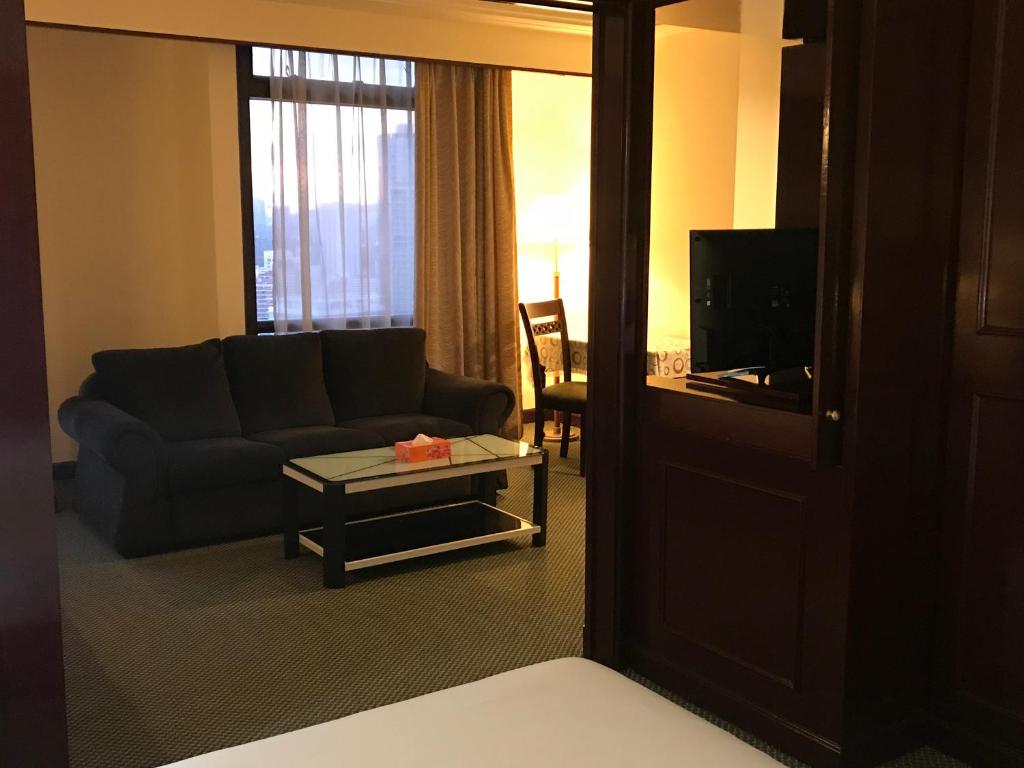 ein Wohnzimmer mit einer Couch und einem Tisch in der Unterkunft KL Service Suites at Times Square KL in Kuala Lumpur