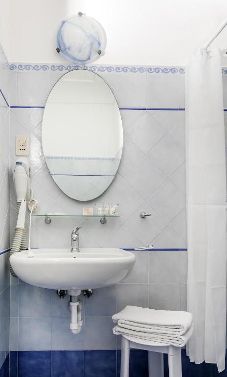 a bathroom with a sink and a mirror at Hotel Pupetto in Positano