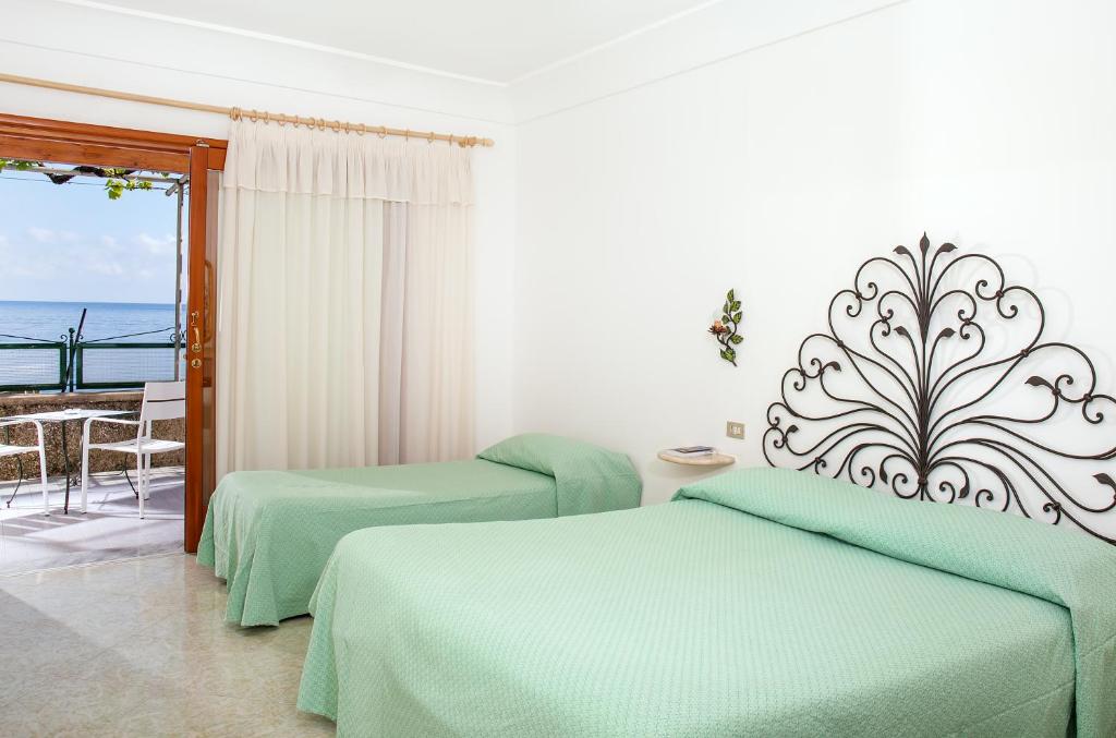 a hotel room with two beds and a balcony at Hotel Pupetto in Positano