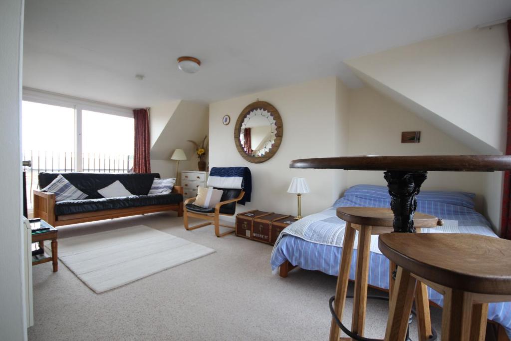 a bedroom with a bed and a living room at Sunnieside Cottage in Seahouses
