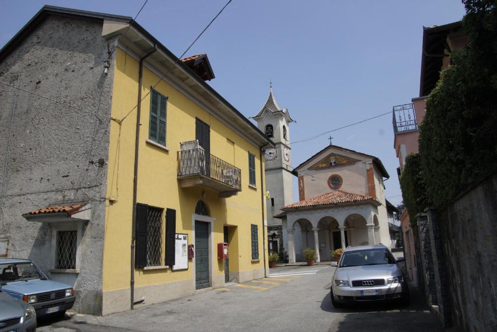 a yellow building with a car parked in a street at Appartamento Cristina in Stresa