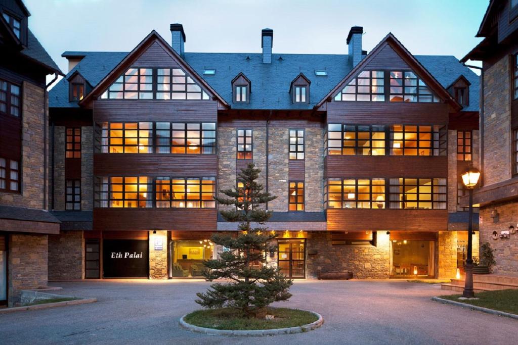 un gran edificio con un árbol de Navidad delante de él en Eth Palai, en Vielha