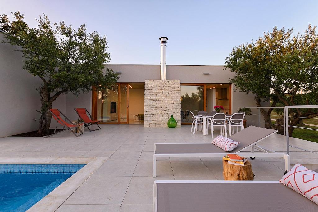 a patio with a table and chairs and a pool at Casa Vari in Rovinj