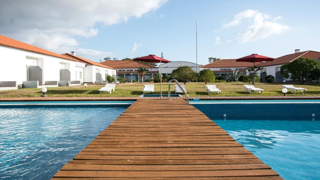 uma ponte de madeira sobre uma piscina numa casa em Hotel Santa Maria em Vila do Porto