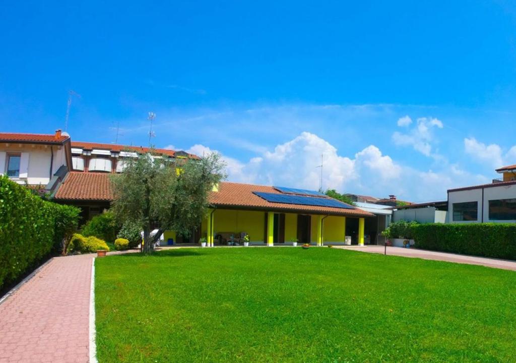 une maison avec une pelouse verte devant elle dans l'établissement Giada Rooms, à Peschiera del Garda