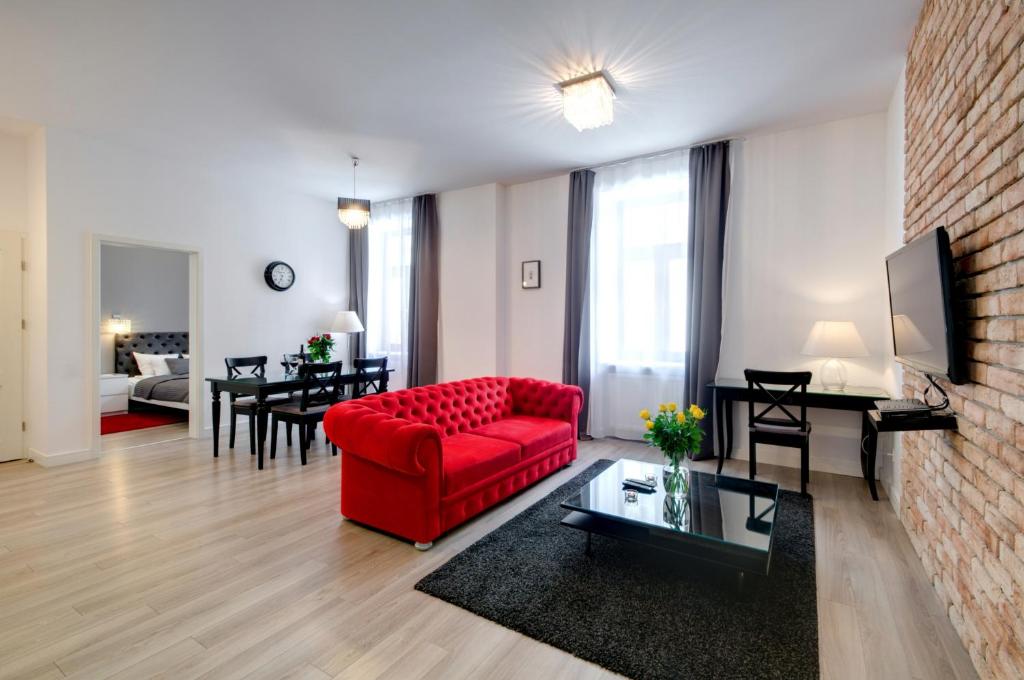 salon z czerwoną kanapą i stołem w obiekcie Zamkowa15 Apartments w Krakowie