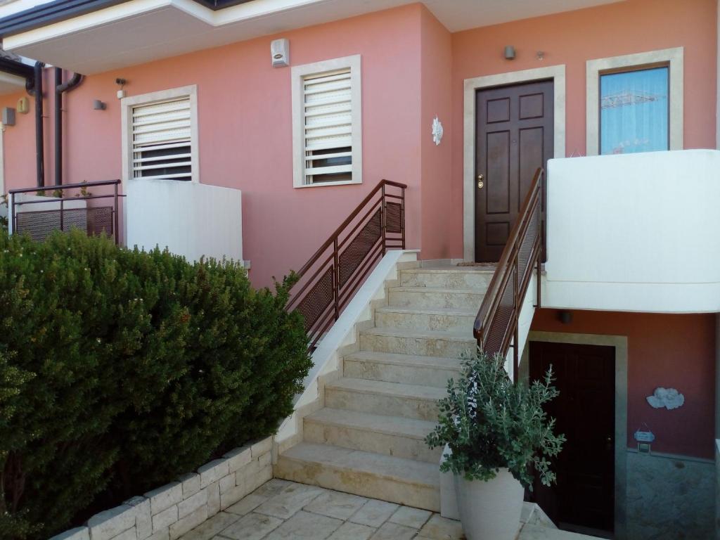 una casa rosa con escaleras y una puerta en B&B VILLA ROSA, en Bitritto