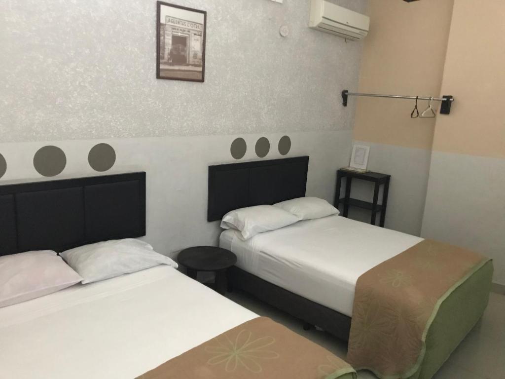 two beds in a small room with two beds sidx sidx sidx at Hotel Central ParQ in Tonalá