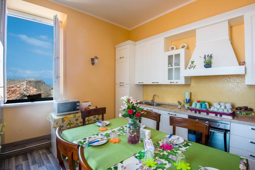 a kitchen with a table with flowers on it at Alla Chiazzetta Calabria in Amantea