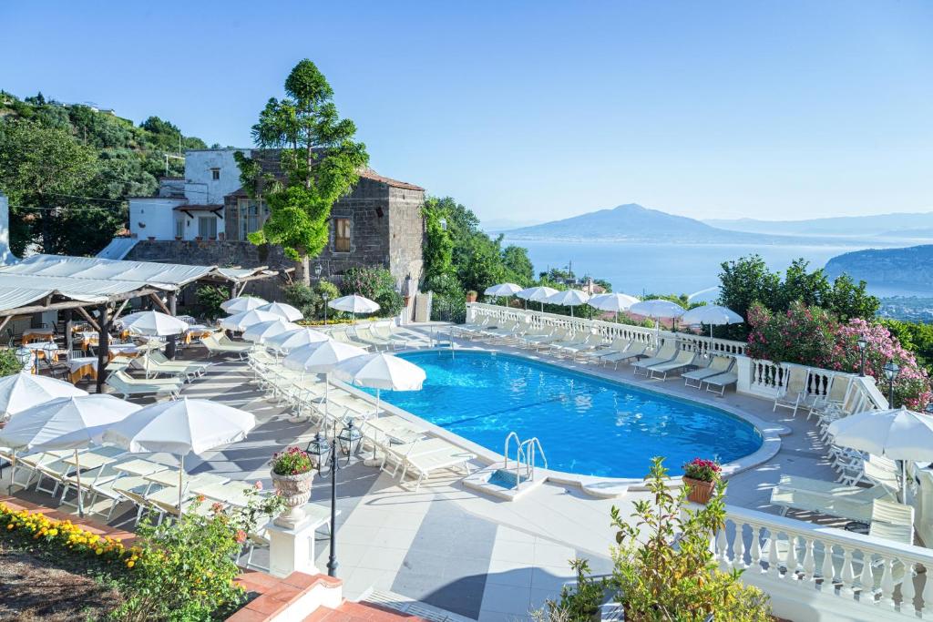 una piscina con sillas y sombrillas en un complejo en Hotel Jaccarino, en SantʼAgata sui Due Golfi