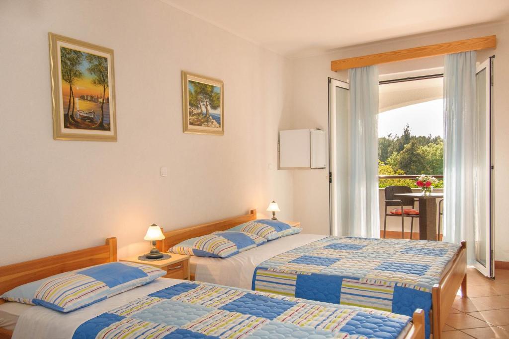 two beds in a hotel room with a balcony at Bed and Breakfast Ritoša in Poreč
