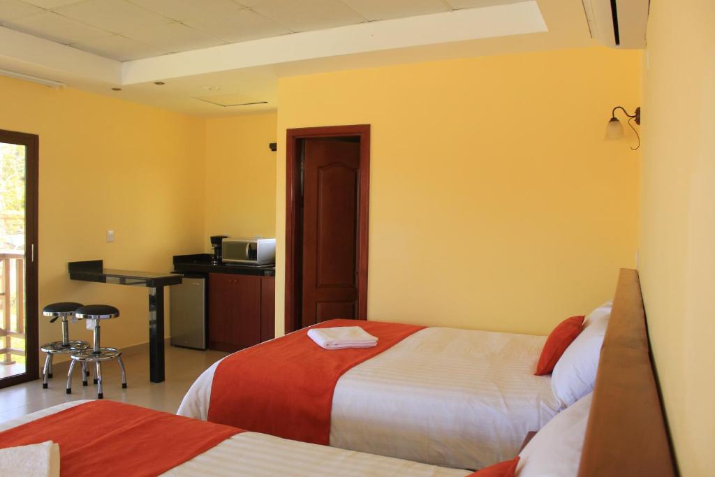 a hotel room with two beds and a desk at Pocri Country Resort in Aguadulce