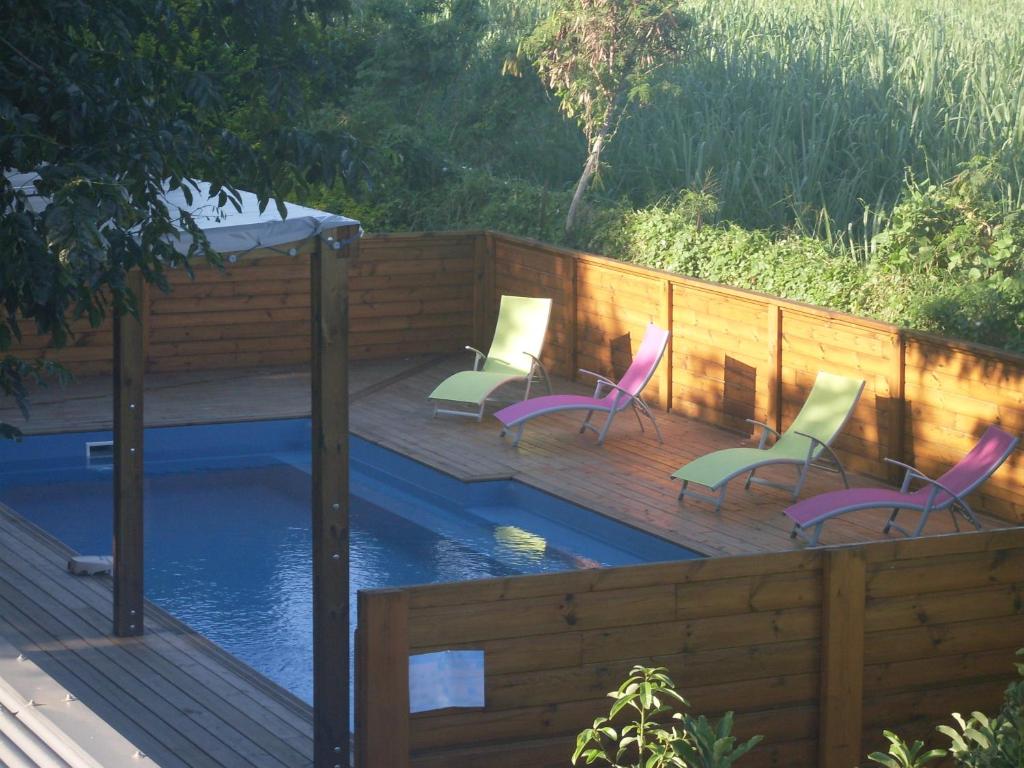 eine Terrasse mit Stühlen und einem Pool in der Unterkunft Auberge d'antan in Saint-Pierre