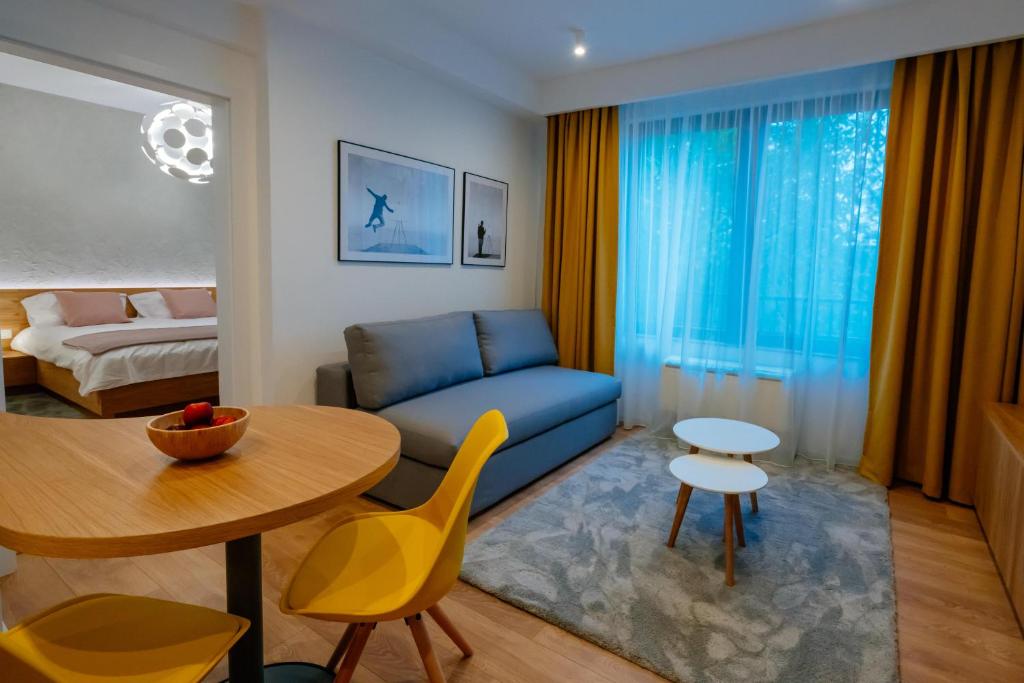 a living room with a blue couch and a table at Arbans Elegant apartment in the city center in Bucharest
