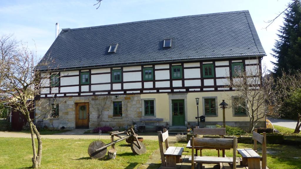 a large white and black house with a bicycle in front at Lichtenhainer Hof in Lichtenhain