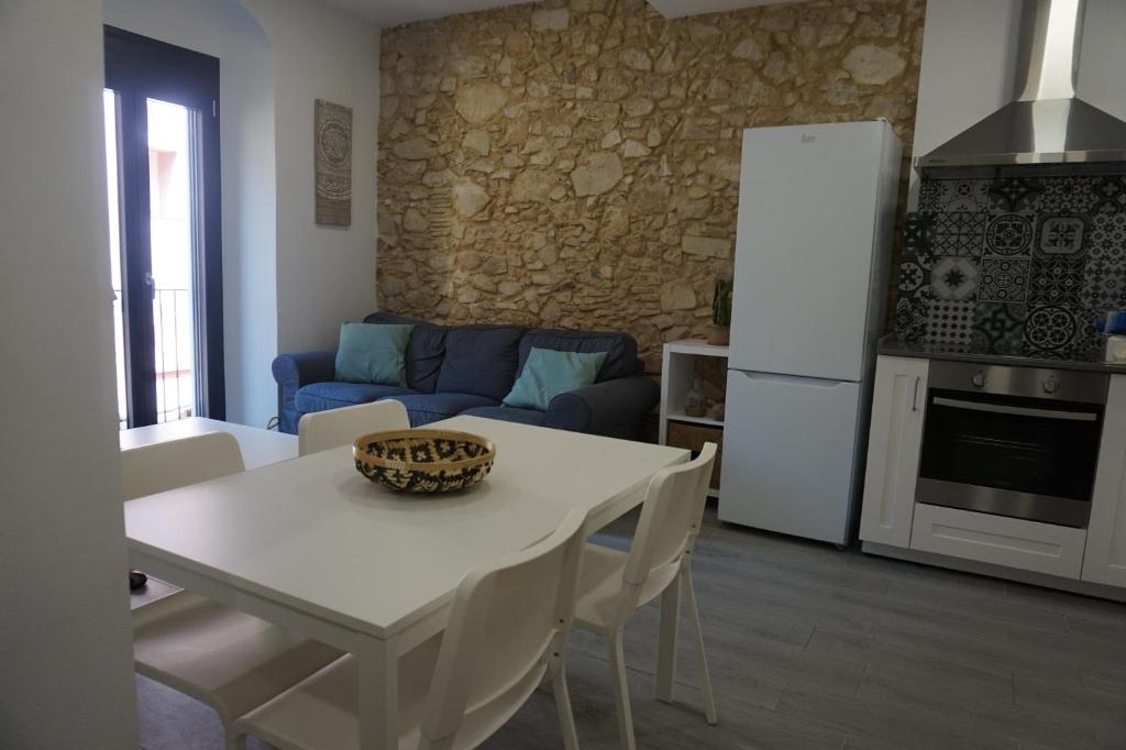 cocina y sala de estar con mesa blanca y sillas en BOREAS Apartaments, en Palamós