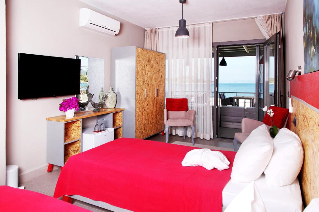 a hotel room with a red bed and a television at Pitahaya Mutfak in Golturkbuku
