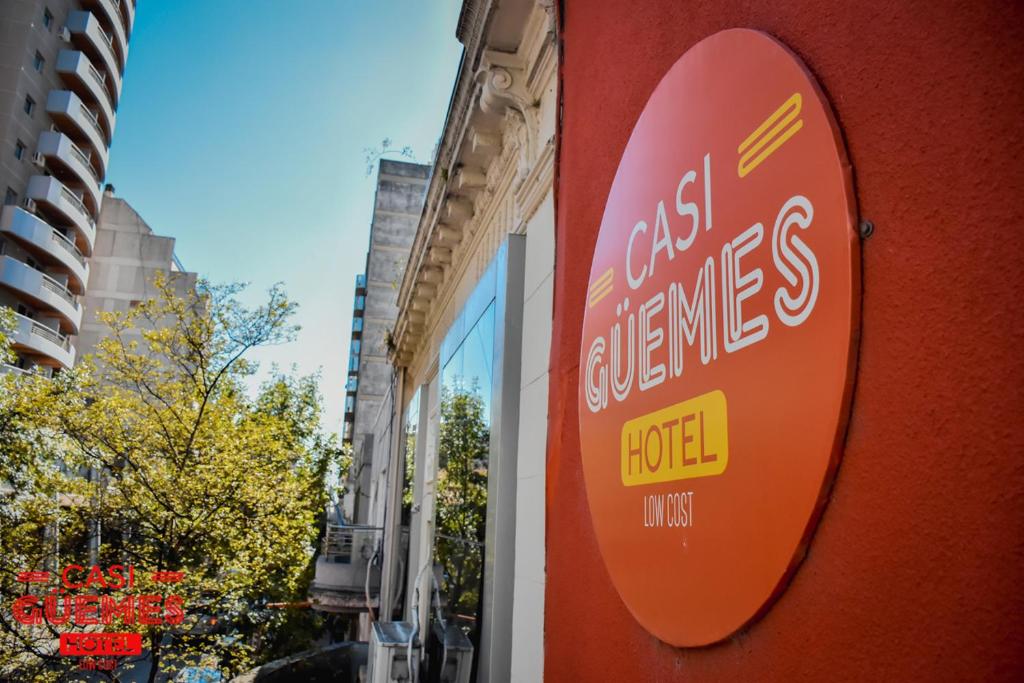 una señal para un hotel al lado de un edificio en Casi Guemes Hotel en Córdoba