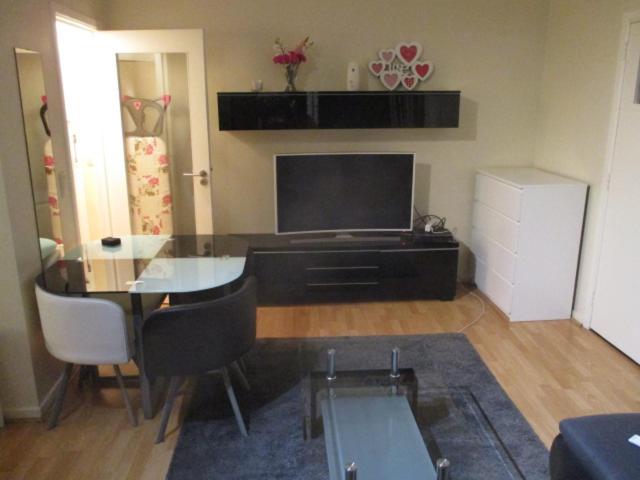 een woonkamer met een glazen tafel en een televisie bij Residence Vleurgat in Brussel