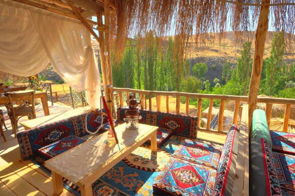 a patio with a table and chairs on a porch at Belisırma Cave Hotel in Aksaray