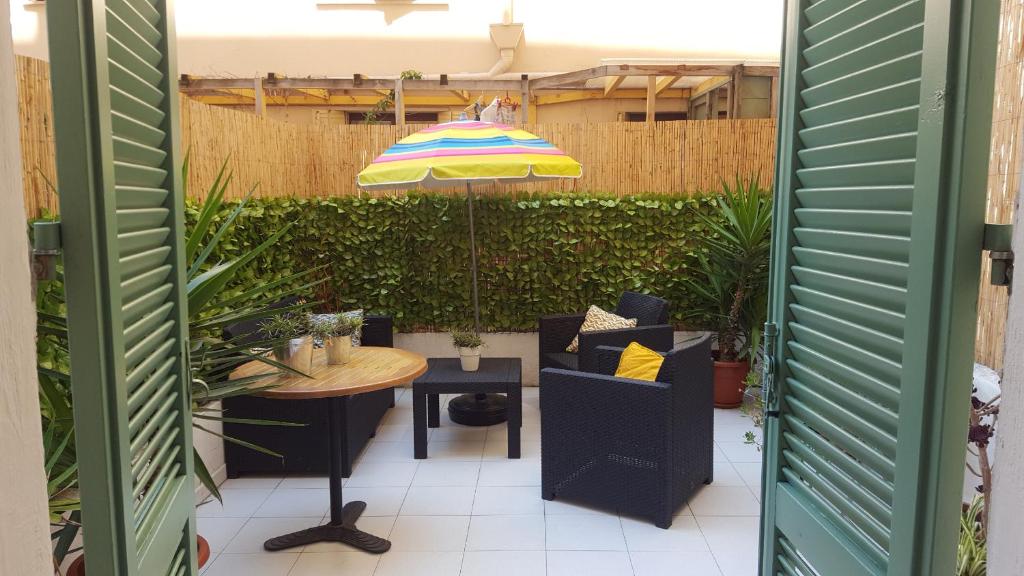 une terrasse avec une table et un parasol dans l'établissement Nice France, à Nice
