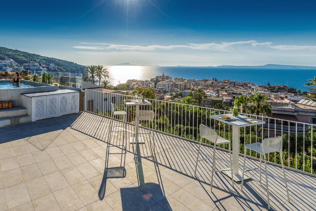 uma varanda com cadeiras e vista para o oceano em Domo 20 Hotel & Rooftop em Vico Equense