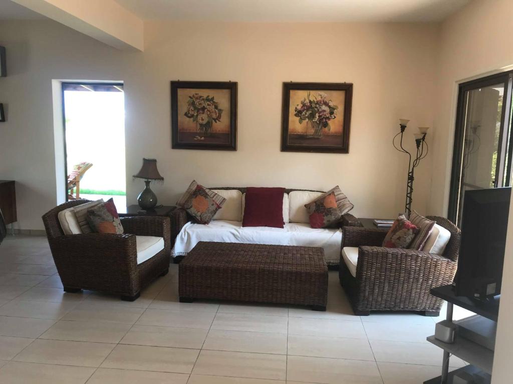 ein Wohnzimmer mit einem Sofa und 2 Stühlen in der Unterkunft Limni Pool House B in Larnaka