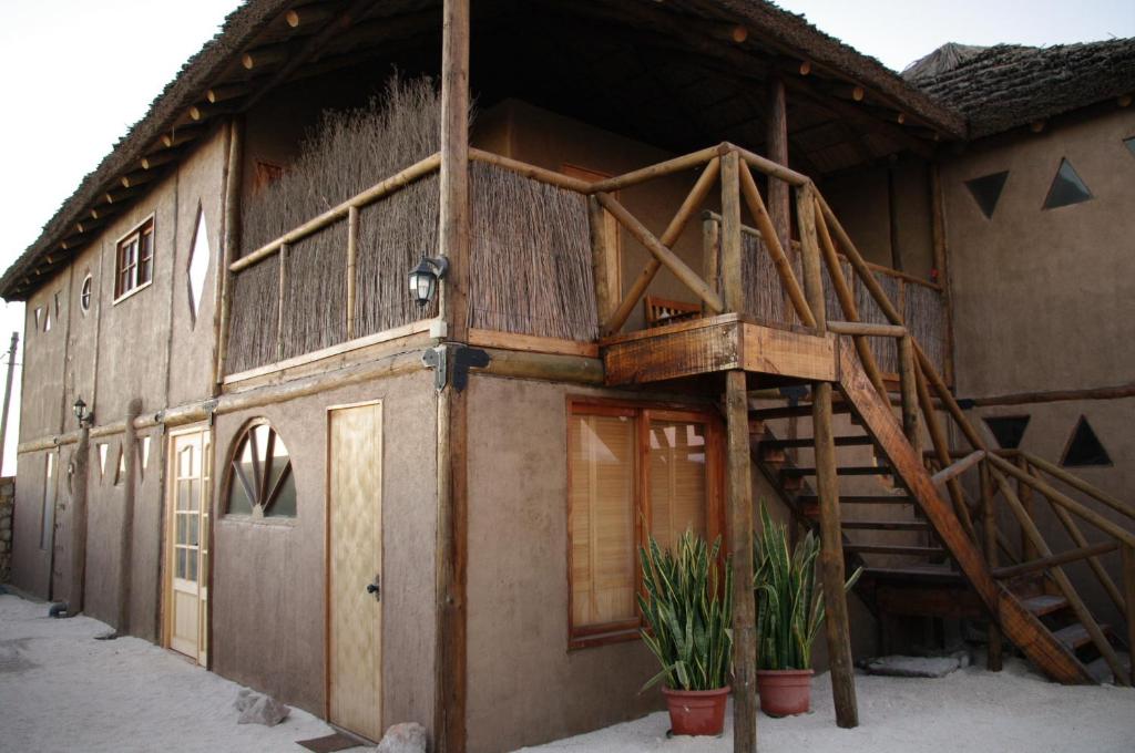 uma casa de madeira com uma escada de madeira em frente em Hospedaje Boutique Ckamur em Caldera