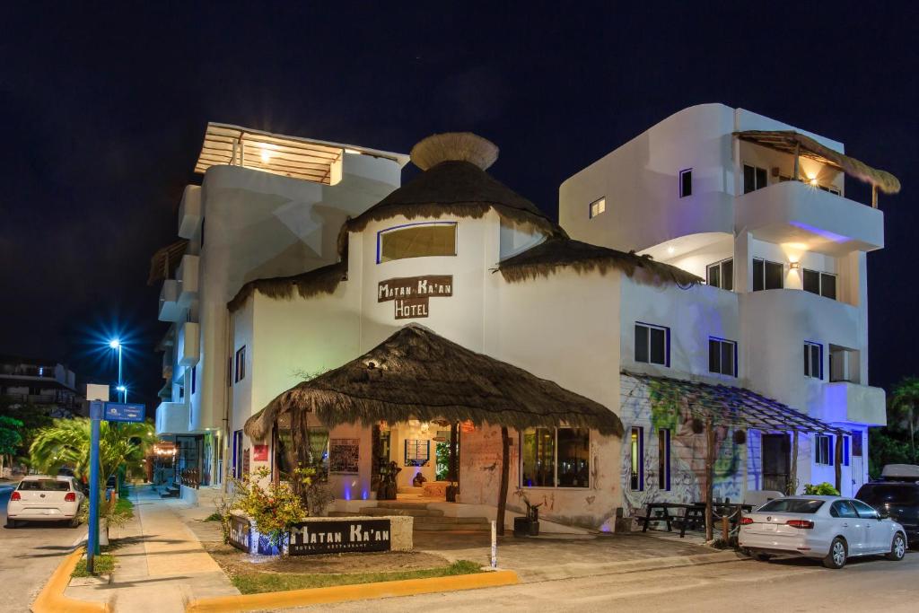 a large white building with a thatheastern at Matan Kaan by GuruHotel in Mahahual