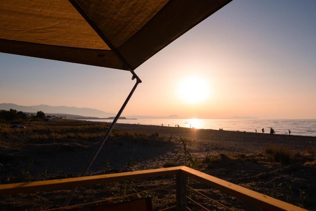 una puesta de sol en la playa desde una tienda de campaña en Camping Elizabeth en Rethymno Town