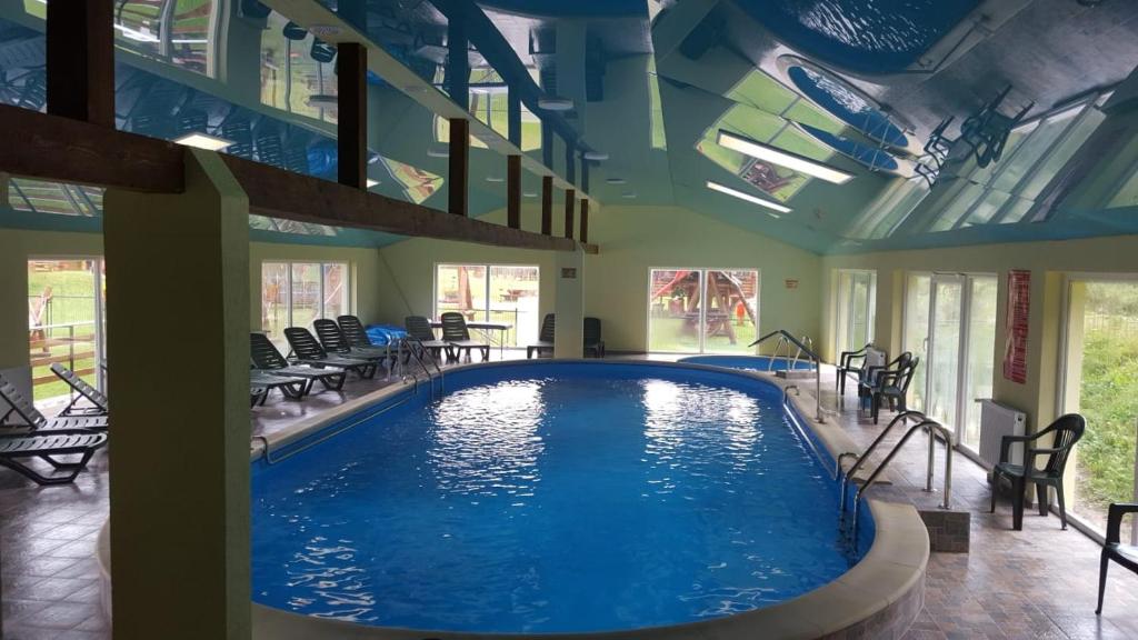 una piscina en una habitación con sillas y una piscina en Casa Siady, en Vatra Dornei