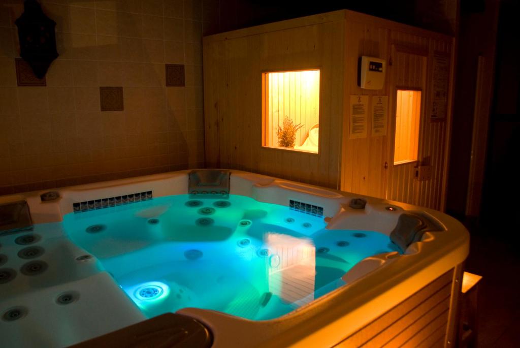 a jacuzzi tub in a room with a window at La Erilla in Braojos de la Sierra