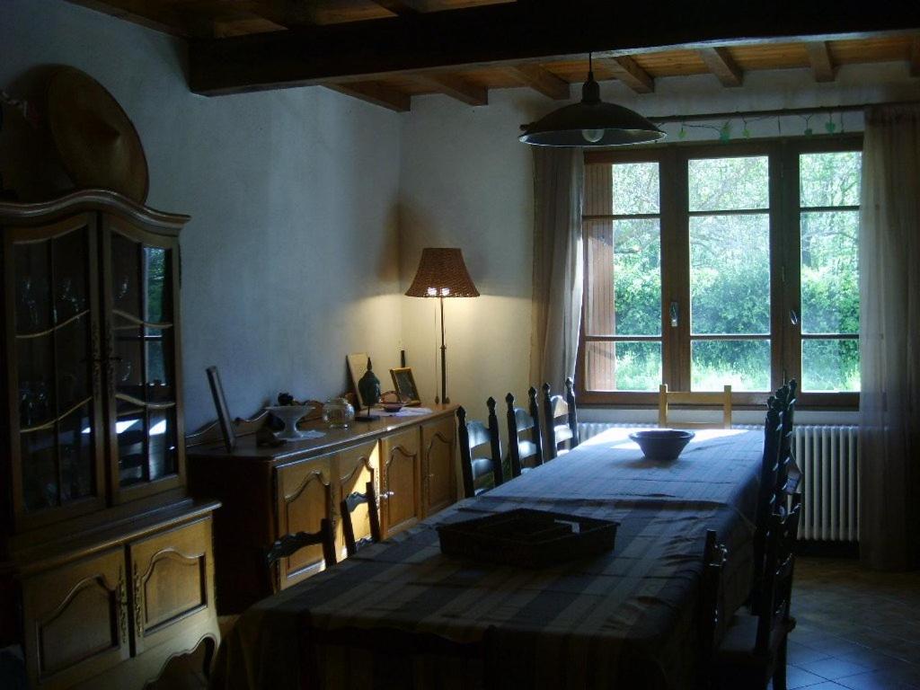 comedor con mesa y cocina con ventana en Le Ribet, en Lempaut