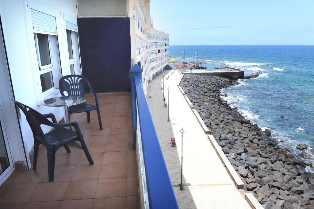 a balcony with a table and chairs and the ocean at Above The Sea Apartment in Bajamar