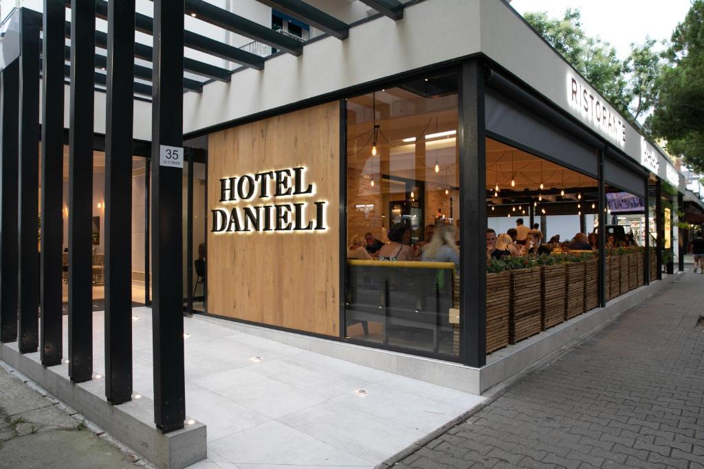 un restaurant avec un panneau indiquant l'hôtel daniel dans l'établissement Hotel Danieli, à Lido di Jesolo
