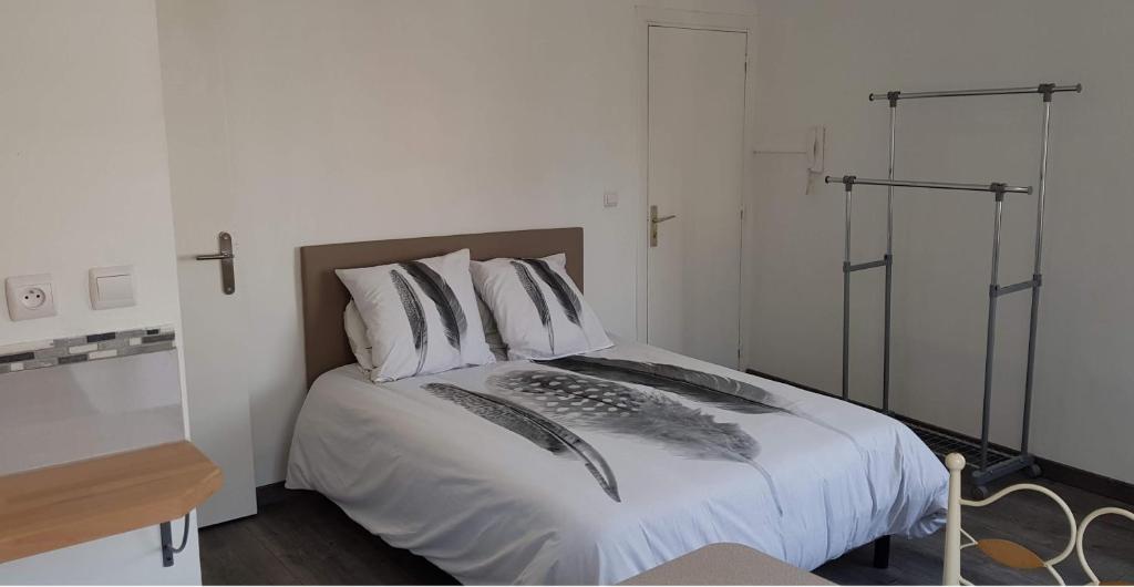 a bedroom with a bed with white sheets and pillows at Val&#39; Appart 1 in Valenciennes