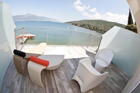 a balcony with chairs and a view of the water at Hotel Baia dei Pini in Torri del Benaco