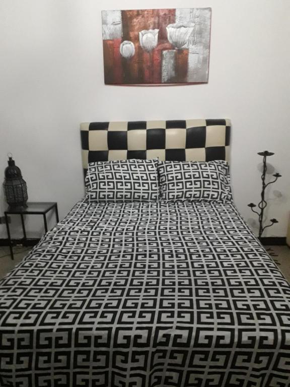 a bed with a black and white comforter in a bedroom at Siwar in Rabat