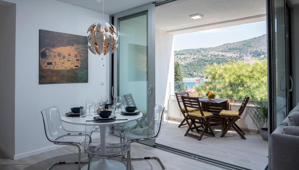 a dining room with a table and chairs and a glass door at Paulina in Dubrovnik