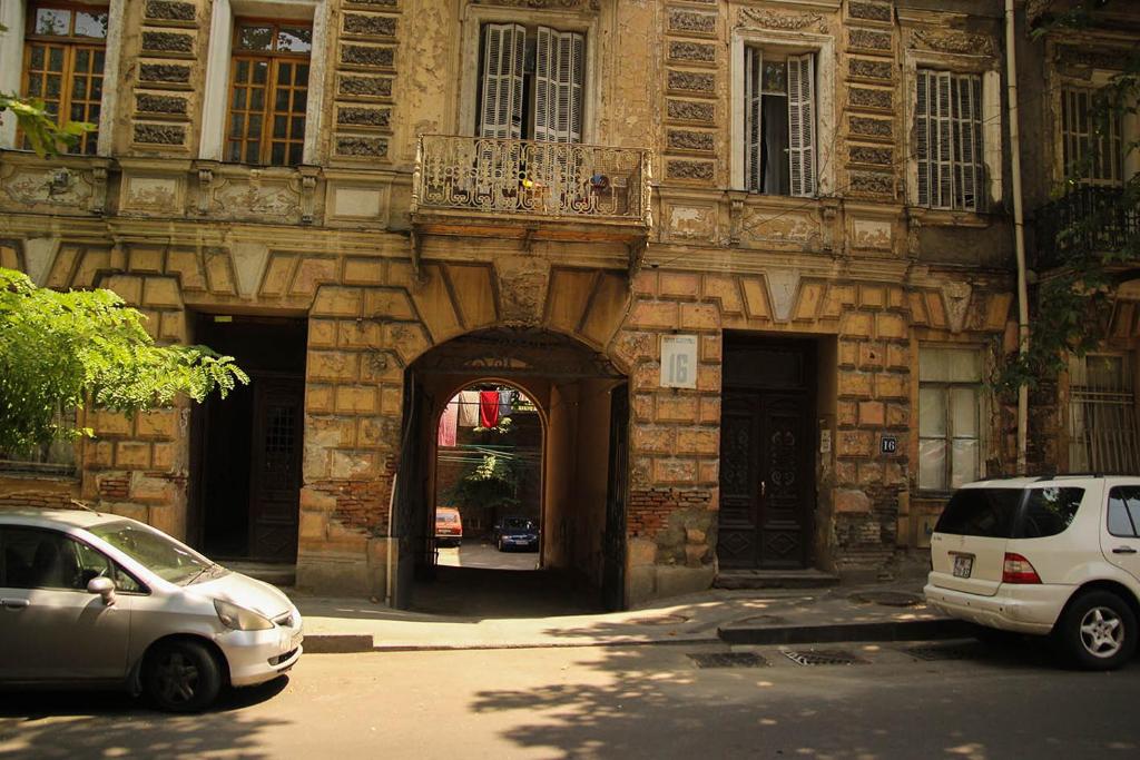 dois carros estacionados em frente a um edifício em Guest house Lana em Tbilisi