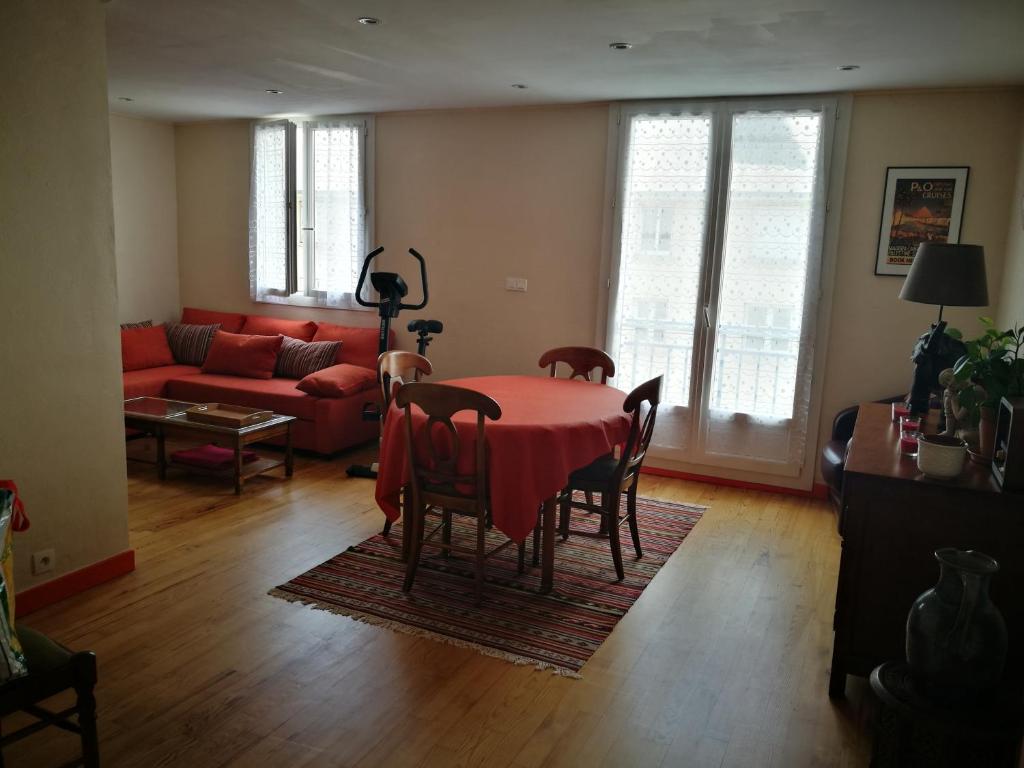 ein Wohnzimmer mit einem roten Tisch und Stühlen in der Unterkunft Proche centre historique 60 m2 in Quimper