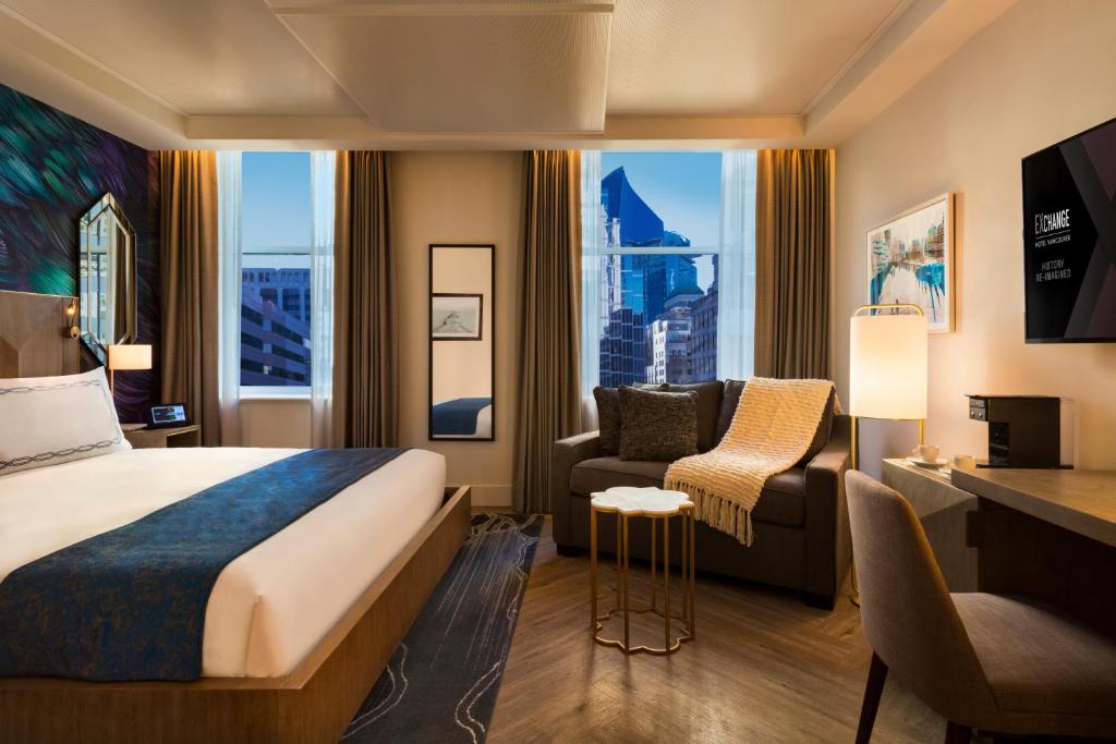 a hotel room with a bed and a desk and a chair at EXchange Hotel Vancouver in Vancouver