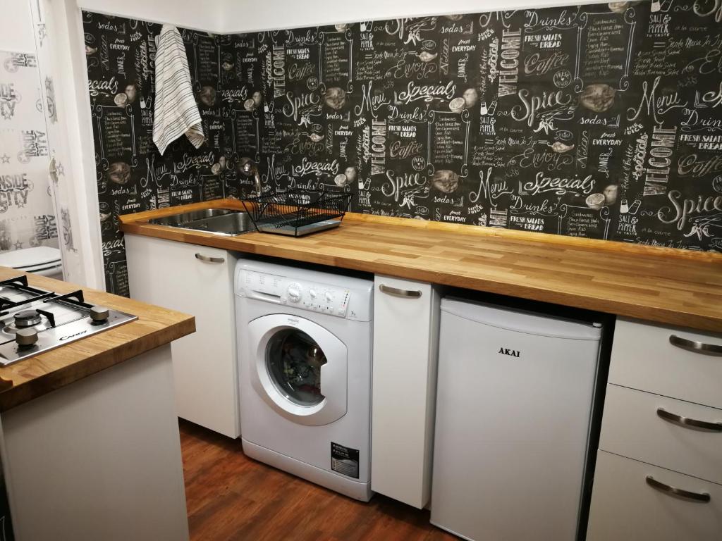 uma cozinha com uma máquina de lavar roupa e uma parede de quadro negro em inside my city em Gênova