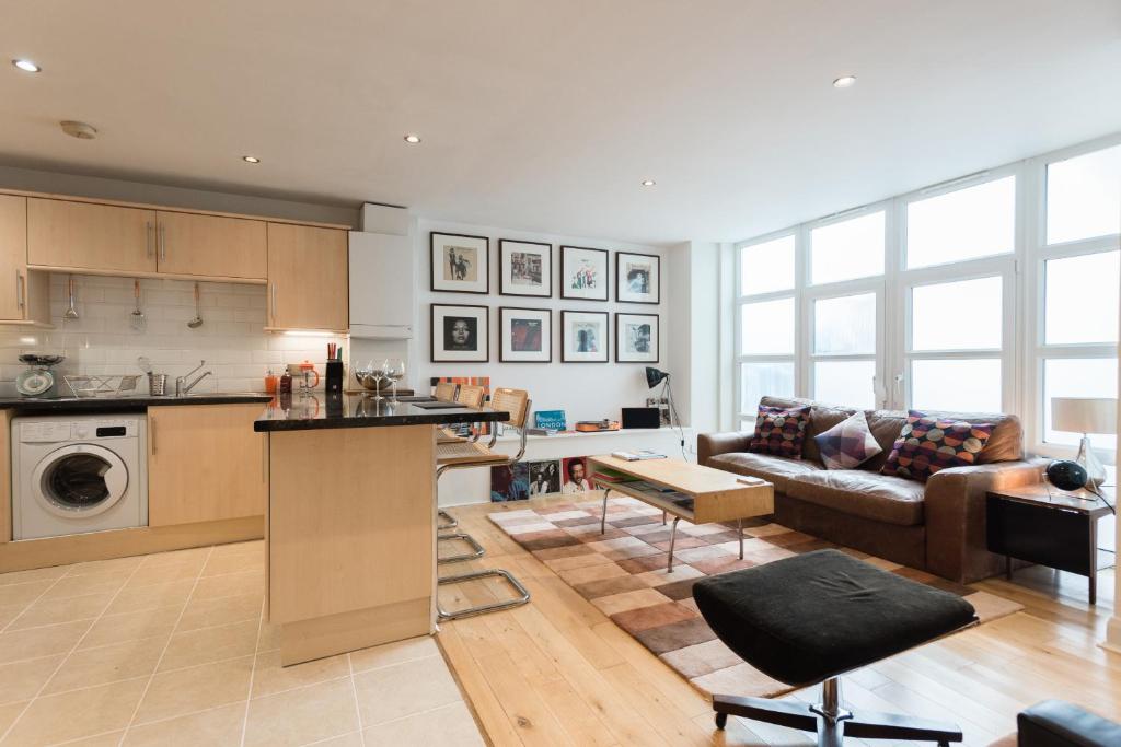 sala de estar amplia con sofá y cocina en Central Home with Parking near Waterloo & St Thomas & Big Ben & Parliament, en Londres