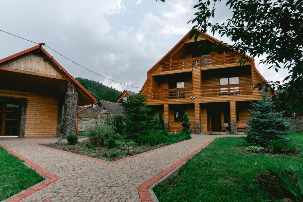 uma grande casa de madeira com uma entrada de tijolos em Kryvyi brid em Yaremche